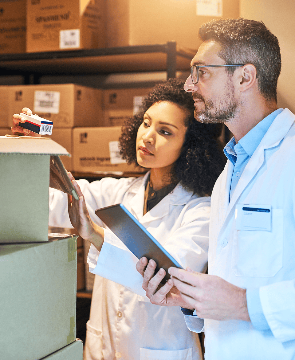 Healthcare professionals inspecting medical supplies in a warehouse.