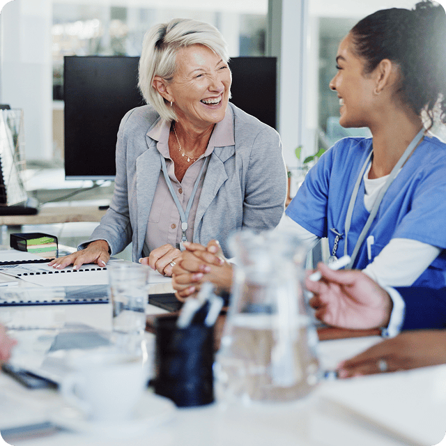 A woman and a healthcare professional smiling and talking in a medical office.