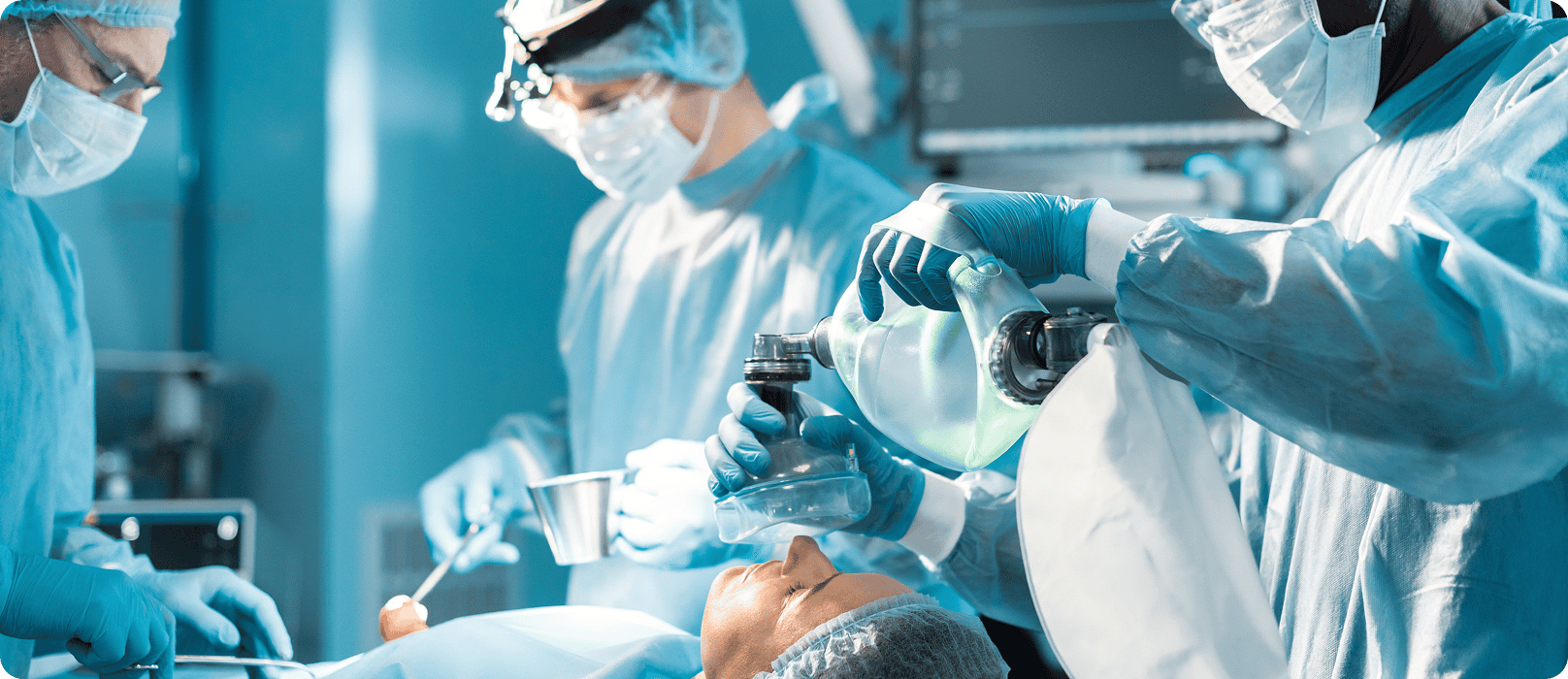 A patient undergoing surgery in a sterile operating room with medical professionals.