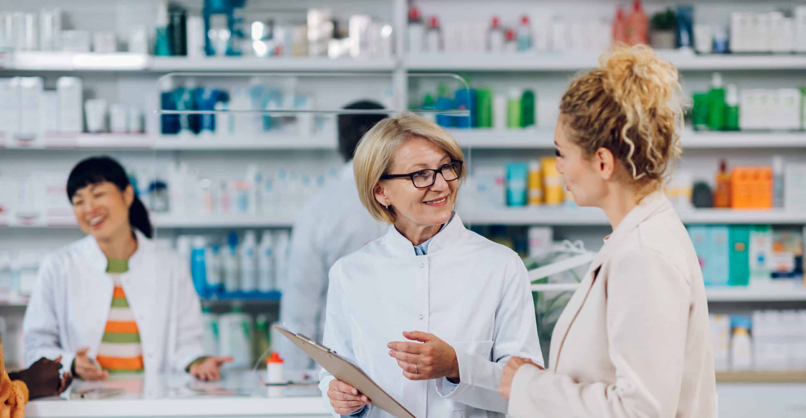 Pharmacists discussing medication in a hospital pharmacy setting.